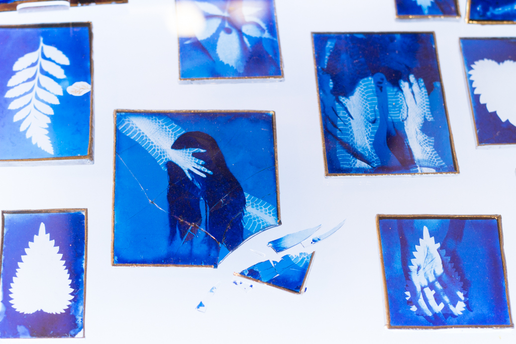 a light box with cyanotypes prints on glass, one of them is broken